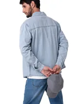 Camisa de manga larga estilo western confeccionada en denim de lavado claro. Presenta cuello camisero, cierre frontal con broches metálicos, dos bolsillos en el pecho con detalle de costuras decorativas y etiqueta de la marca, y dobladillo redondeado.