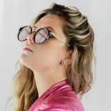 Aros pequeños de plata 950 con forma circular y detalle de piedra rosada.