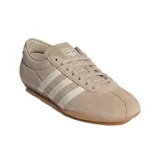 Championes Adidas Tokyo de mujer, confeccionados en gamuza suave de color beige con las icónicas tres tiras y detalles en blanco, y suela de caucho.