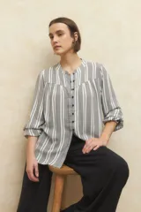 Camisa de manga larga con puños elastizados, cuello mao y botones a tono. Estampada con rayas verticales blancas y grises.