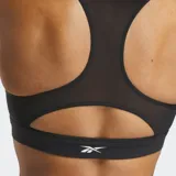 Top deportivo Reebok de soporte medio, confeccionado en tela Nylux con diseño de espalda nadadora. Presenta un color negro predominante con detalles en color menta en los laterales y copas internas para mayor soporte.
