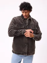 Sobrecamisa de pana color beige, con cierre frontal de botones a presión, dos bolsillos frontales con solapa y bolsillos laterales. Presenta cuello clásico y diseño acolchado con forro interior.