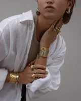 Pulsera tipo esclava abierta con diseño rústico y acabado irregular, fabricada en bronce y alpaca.