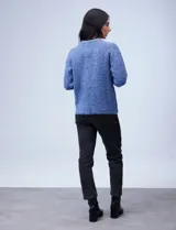 Buzo de lana melange color tostado, con cuello redondo y mangas largas.