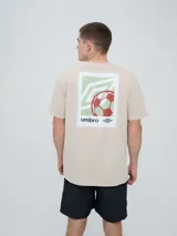 Remera de manga corta color beige, con cuello redondo y diseño holgado. Cuenta con un pequeño estampado rectangular en el pecho con motivo futbolero.