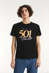 Remera de algodón negra con cuello redondo y mangas cortas. Presenta un estampado gráfico frontal con el logo de Levi's y la inscripción '501 Blues' en tonos amarillos y violetas.