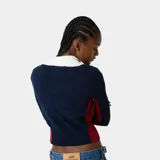 Cardigan de punto Eme Studios modelo Betty Navy, de color azul marino con cuello alto y puños blancos, y detalles en rojo en los laterales. Cuenta con cierre frontal de cremallera y logo bordado en relieve en el pecho.
