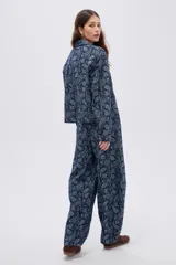 Campera de denim azul con estampado estilo paisley, cierre frontal con botones metálicos y cuello camisero.