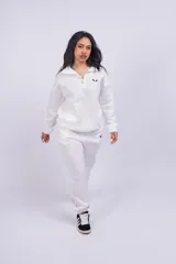 Pantalón de jogging color beige con cintura elástica y logo estampado en blanco en el muslo.