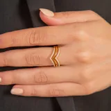 Anillo de oro 9k con diseño en forma de V, compuesto por dos bandas unidas, una de ellas con engaste de circonias brillantes.