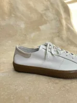 Championes de cuero con estampado animal print en blanco y negro, cordones negros y suela de goma color caramelo.