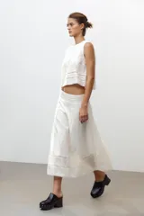 Top blanco de algodón con cuello redondo y sin mangas. Presenta bordados a tono y cierre trasero con abertura y botón.