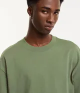 Remera de corte relaxed y mangas cortas, confeccionada en algodón de efecto pesado, con cuello redondo y diseño liso en color gris.