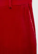 Pantalon de vestir de corte recto y tiro alto, confeccionado en tejido de terciopelo color rojo. Presenta cierre de cremallera en la parte posterior y trabillas para cinturón.