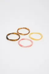 Pack de tres pulseras rígidas de resina en tonos tostado, marrón carey y rosado translúcido, con diseño de formas orgánicas.