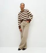 Suéter de cuello redondo confeccionado en tejido de chenille con diseño de rayas horizontales. Presenta mangas largas con puños acanalados y bajo ajustado, ofreciendo una textura suave y aterciopelada.