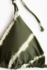 Top de bikini de triángulo con estampado tie-dye en tonos verde militar y blanco, breteles ajustables y tiras para anudar en la espalda y el cuello.