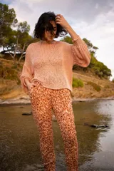 Pantalón de algodón color beige con estampado de manchas marrones, corte holgado que se estrecha hacia los tobillos y cintura ajustable con cordón.