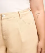 Short color beige de corte evasé, con cintura alta, bolsillos delanteros y traseros, trabillas en la cintura y bajo deshilachado.