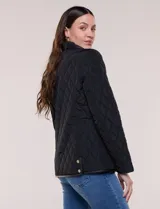 Campera matelaseada Michael Kors, de color beige con ribetes de ecocuero marrón. Cuenta con cuello con solapa, cierre frontal con broches metálicos, bolsillos laterales con cierre y mangas largas.