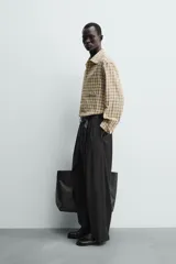 Camisa relaxed fit de algodón con elasticidad, color amarillo y gris a cuadros. Tiene cuello solapa, manga larga con puño abotonado, bajo con aberturas laterales y cierre frontal de botonadura.