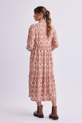 Vestido camisero midi color marrón con estampado geométrico en blanco, de corte recto, con cuello camisero, abotonadura frontal y mangas largas con puños abotonados.