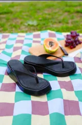 Sandalias de plataforma color negro, tipo ojota con suela gruesa y diseño de punta cuadrada.