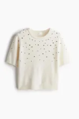Top de punto fino de manga corta con cuello redondo, decorado con aplicaciones de strass en la parte frontal y acabados acanalados en cuello, puños y bajo.