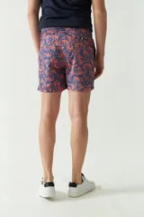 Short de baño estampado con diseño geométrico en tonos verdes, cintura elástica con cordón ajustable, bolsillos laterales y bolsillo trasero.