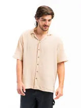 Camisa color crema de tela tetra de algodón, de corte suelto, manga corta y cuello cubano.