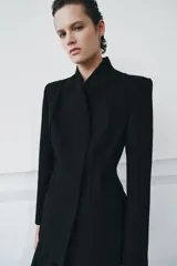Blazer entallada color negro de ZARA Woman Collection, con escote en pico, manga larga con hombreras, bolsillos con solapa en el delantero y cierre frontal con botones ocultos.