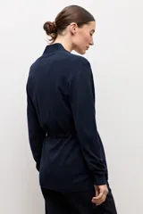 Ruana básica de tejido azul marino con cuello en V, cordón ajustable en la cintura y bolsillos frontales.
