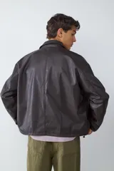Campera de efecto cuero en color marrón oscuro, con cuello camisero, cierre frontal con cremallera y bolsillos frontales tipo parche.