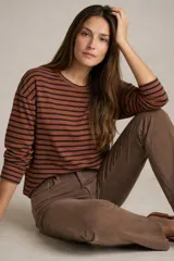 Remera de manga larga con cuello redondo, confeccionada en algodón con elastano. Presenta un diseño de rayas horizontales en color camel y negro.