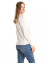 Buzo de punto liviano color blanco, con cuello redondo y mangas largas con frunce en la copa. Presenta apliques de strass en forma de destellos distribuidos en el frente. Cuenta con puños y cintura en tejido acanalado.