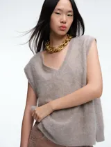 Chaleco tejido sin mangas con escote en V, confeccionado en cashmere con textura suave y diseño de líneas simples.