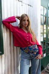 Camisa corta simil lino color fucsia, con cuello en V y abotonadura frontal.