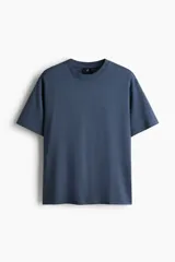 Remera de algodón de peso medio, color azul, con cuello redondo ribeteado, hombros caídos y corte relajado.