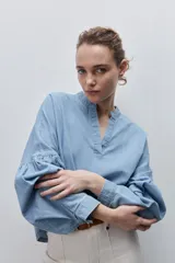 Blusa de denim de algodón con escote en V y cuello mao, de calce amplio y mangas largas con detalle fruncido.