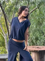 Conjunto de dos piezas color azul marino, compuesto por una remera de manga tres cuartos con escote en V y una babucha de tiro alto con bolsillos laterales y puños elastizados.