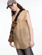 Camisa negra sin mangas con cuello mao y cierre frontal con botones.