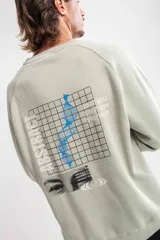 Buzo verde claro con cuello redondo, corte oversize y estampado lateral con texto en negro.