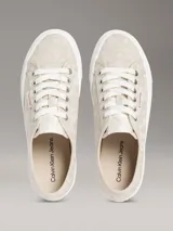 Zapatillas de plataforma Calvin Klein con diseño de jacquard monograma en tonos beige, suela blanca gruesa y cordones blancos.