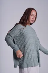 Sweater negro de punto con diseño de ochos, cuello redondo y mangas largas.