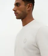 Remera de algodón con cuello redondo y manga corta, de corte holgado y diseño minimalista con un pequeño sello náutico estampado en el pecho.