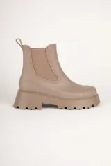 Botas Chelsea negras de caña baja, con elástico lateral y suela track.