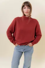 Polera de tejido de punto con textura marcada, cuello alto y diseño oversize con hombros caídos y terminaciones acanaladas.