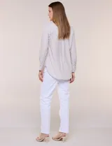 Camisa de calce relajado color celeste, confeccionada en tejido de textura suave y fluida. Presenta cuello camisero y abotonadura frontal, mangas largas con puño ancho y ruedo curvo.
