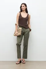 Pantalón recto color verde oliva, con bolsillos laterales y cierre frontal con botón y cremallera.