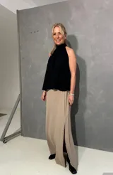 Falda larga beige de corte recto con tajo lateral, confeccionada en viscosa y elastano, con pretina lisa al frente y elástico en la parte posterior.